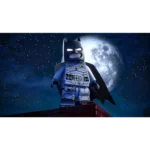 LEGO Batman minifigure stands on a rooftop at night, with a glowing full moon behind him.
