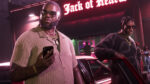 Two stylish men stand beside a neon-lit club entrance at night; one in a cream knit shirt checks his phone, the other leans on a car door wearing a dark sweatshirt and sunglasses.