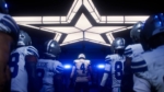 4834d61a-a174-4a97-8bda-58f7838de1ff - Video Game Depot Football players in white uniforms walk through a lit tunnel toward the field, a bright star-shaped ceiling above them guiding the way.
