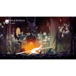Small white knight-like character fights a bright energy beam in a dark, gothic cavern with glowing lanterns and eerie structures.