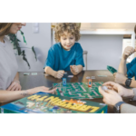 61C53KAJTRL_AC_SL1024___872181785270583 - Video Game Depot Family game night: a boy in a blue shirt concentrates on moving pieces on a board game while adults sit around the table with cards nearby.
