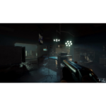 First-person shooter view in a dark medical room with a shotgun raised, surgical lights overhead and medical equipment around.