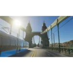 71flpCoKy5L_SL1500___880421773762803 - Video Game Depot Ornate suspension bridge with twin towers, a blue train on the left, sun glare, and desert hills in the background.