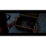 A dark wooden box opened to reveal a handgun and loose bullets on its bottom, held by a person’s hands over a rough surface
