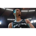 Close-up of a basketball player in a Spurs jersey looking upward under bright arena lights.