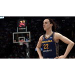 Female basketball player in Indiana jersey #22 stands on the court with hands on hips, arena in background and crowd watching.