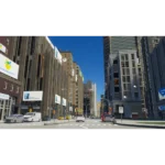 81rBKM-kw5L_SL1500___316991773762803 - Video Game Depot Urban street scene with tall modern buildings, parked cars, and a clear blue sky on a sunny day.