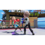 Nintendo_Switch_Sports_Resort_Screen_1__752001781039454 - Video Game Depot Young girl in boxing attire throws a punch at a boy as they spar in a bright outdoor boxing ring with ropes and spectators nearby.