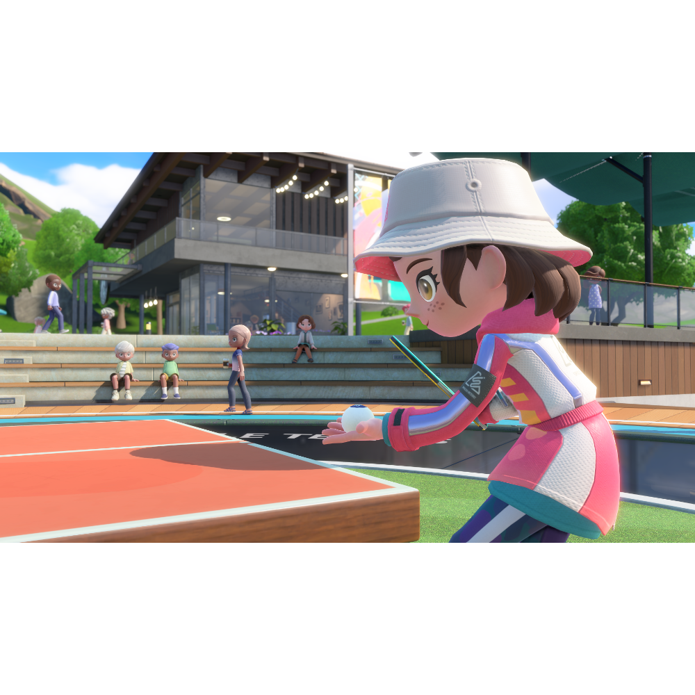 Female player in a pink outfit and white bucket hat prepares to serve a ping-pong ball at an outdoor table tennis court, with spectators on the steps behind.