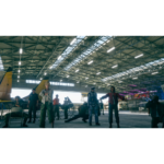 b39c7fdc-1c78-4b47-accc-b814a30ebae7__190871781184901 - Video Game Depot People in a large aircraft hangar posing for a photo, some in flight suits.