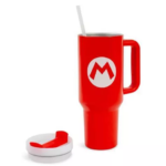 Red insulated travel mug with a white straw and a white circular emblem featuring a red 'M'; a matching lid sits nearby on a white surface.