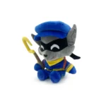 Plush raccoon character wearing a blue cap, gray face, yellow scarf, blue outfit, seated with a curved yellow staff.