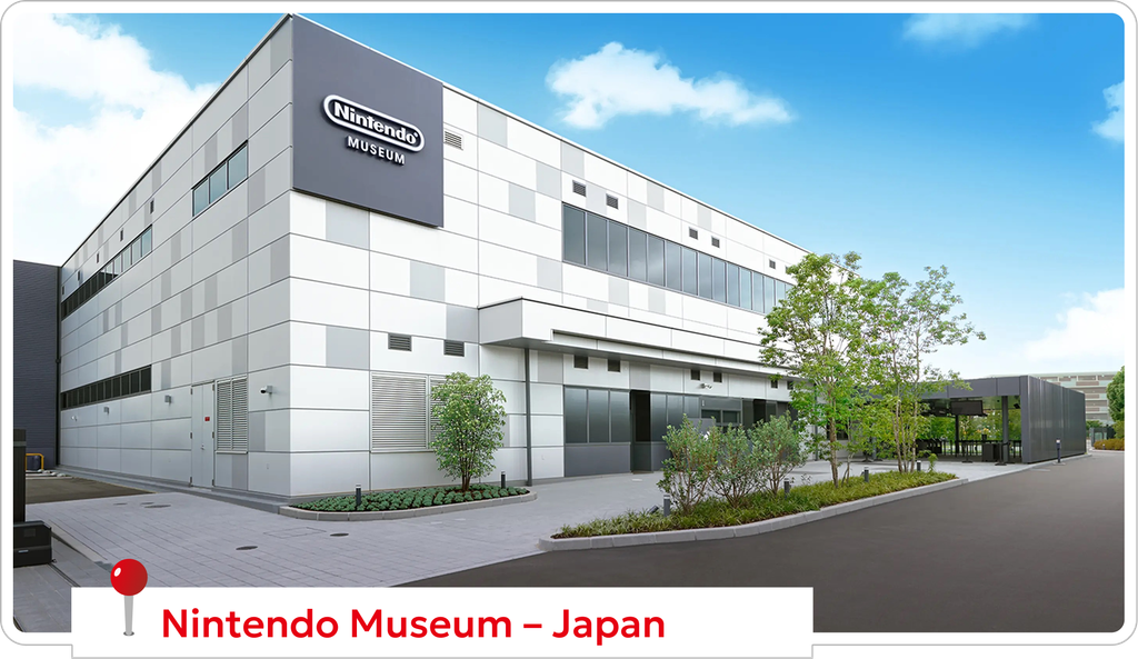 Exterior view of the Nintendo Museum building in Japan, a modern gray-white complex with large windows, under a blue sky.