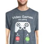 VIDEO-GAMES-ARE-CALLING-TSHIRT-006 - Video Game Depot Person wearing a gray T-shirt with the text 'Video Games are calling' and a large game controller graphic on the chest.