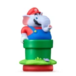 Plastic elephant toy wearing a red cap and blue overalls peeking out of a green Mario-style pipe on a grassy base with a butterfly nearby