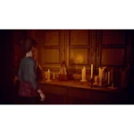 Girl with back to camera stands beside a candlelit wooden table in a dim, warm room.